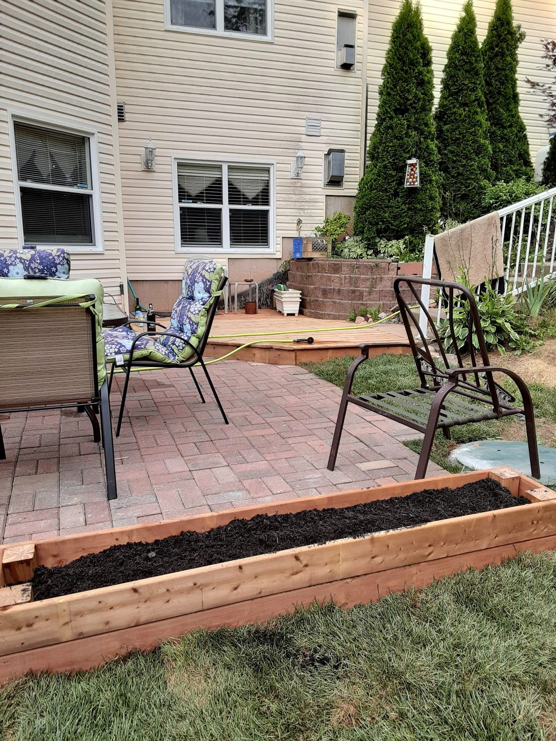Paver patio with a low deck landing and a cedar raised planter box